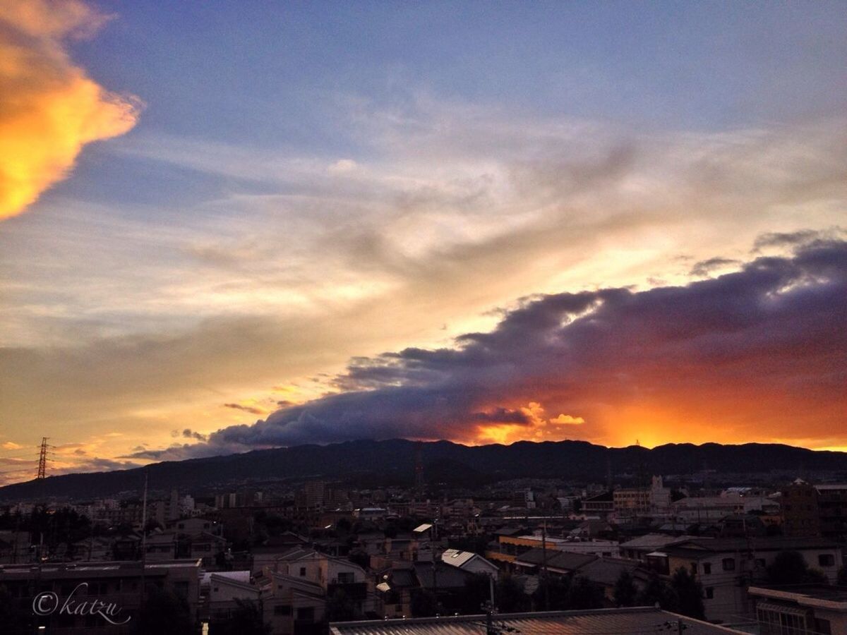 sunset, building exterior, architecture, built structure, sky, orange color, cityscape, city, cloud - sky, high angle view, residential district, townscape, residential structure, town, residential building, house, mountain, cloud, crowded, scenics