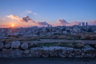 Buildings against sky during sunset in city