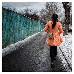 Rear view of man walking on road