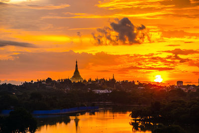 Illuminated buildings against sky during sunset