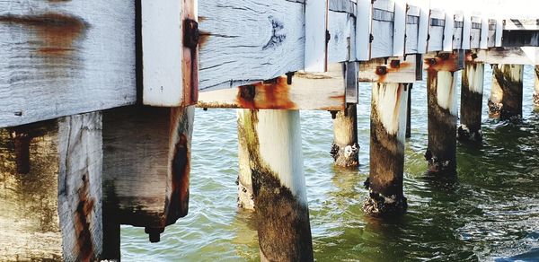 Wooden posts on pier by river
