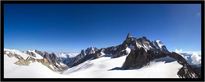 Scenic view of snowcapped mountains against clear blue sky