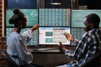 Business colleagues brainstorming while looking at computer monitor