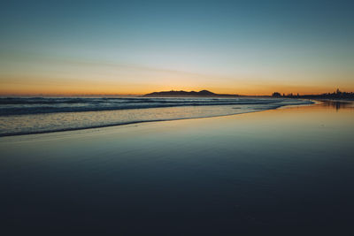 Scenic view of sea against clear sky at sunset