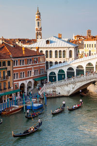 Boats in canal passing through city buildings