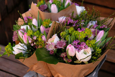 Beautiful bouquet is packaged in kraft paper. flowers in metal container, wooden boxes, loft, craft.