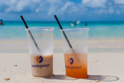 Close-up of glasses on beach against sky