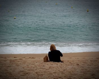 Rear view of people sitting on beach