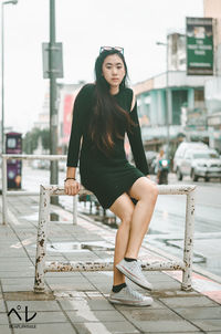 Portrait of beautiful young woman against built structure