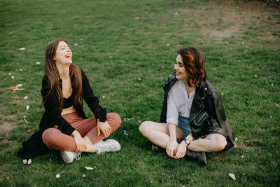 Young woman sitting on grass in field