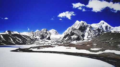 Snow covered mountain against blue sky