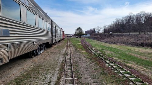 Railroad track amidst field against sky