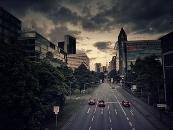 Cars on city street against sky