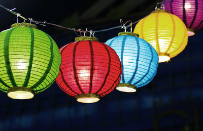 Low angle view of illuminated lanterns hanging at night