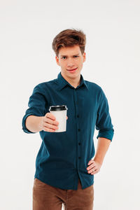 Portrait of young man using smart phone against white background