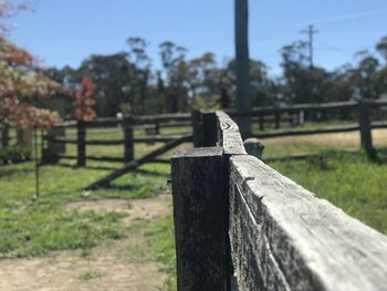 Wooden fence on field against sky