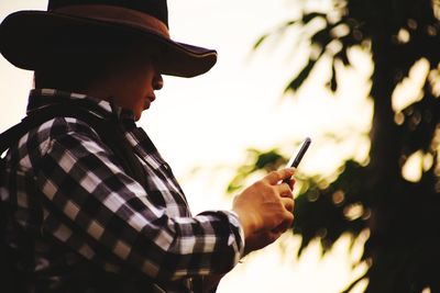 Side view of man holding mobile phone