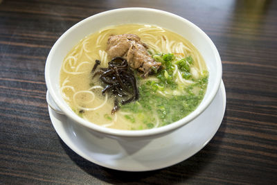 High angle view of chicken soup in bowl served on table