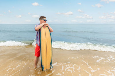 Portrait of young woman standing at beach