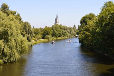 Scenic view of river amidst trees against sky