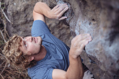 High angle view of young man climbing rock