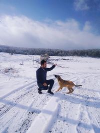 Full length of a dog on snow covered field