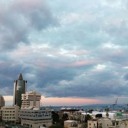 View of cityscape against cloudy sky