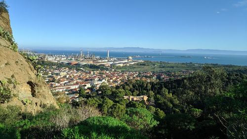 High angle view of townscape by sea against clear sky