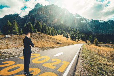 Rear view of man on road against mountains