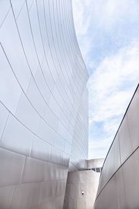 Low angle view of modern building against cloudy sky