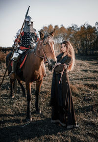 Woman riding horse on field