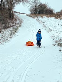 A boy skiing on snow covered field