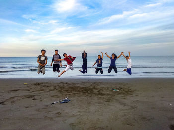 People at beach against sky