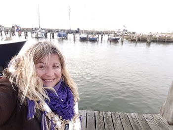 Portrait of happy mature woman standing at harbor