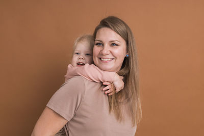 Portrait of cute baby boy against yellow background