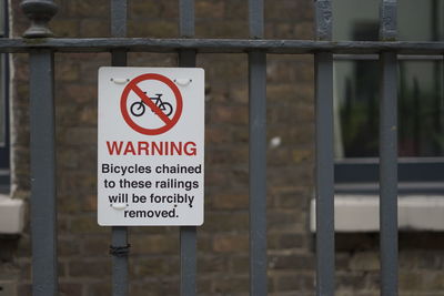 Close-up of warning sign on railing