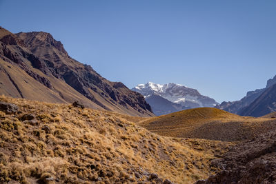 Scenic view of mountains against clear blue sky