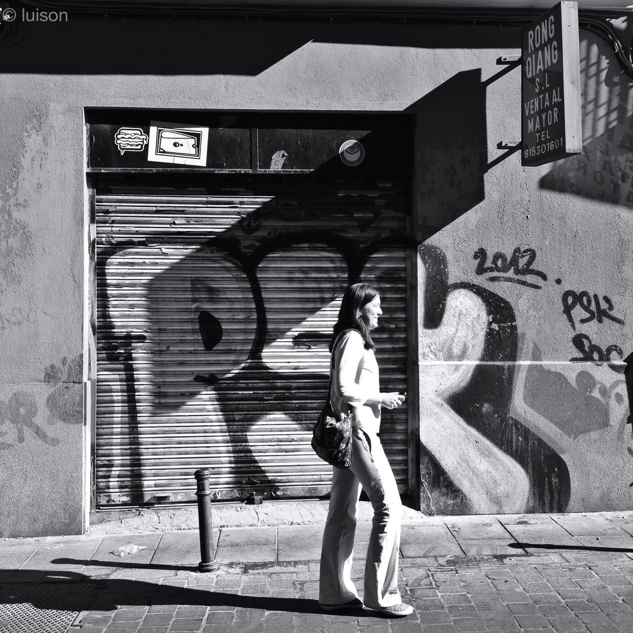 full length, architecture, built structure, building exterior, lifestyles, casual clothing, standing, leisure activity, street, graffiti, young adult, wall - building feature, men, side view, rear view, sunlight, walking, building