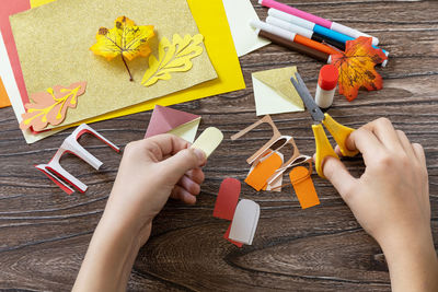 High angle view of man holding pencils on table