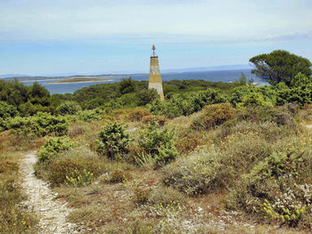 Lighthouse by sea against sky