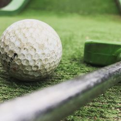 Close-up of golf ball on grassland