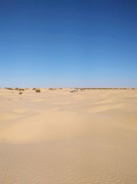 Scenic view of desert against clear blue sky