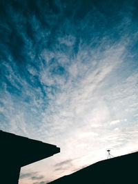 Low angle view of silhouette cross against sky