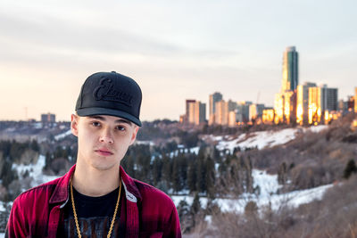 Portrait of man standing against sky in city