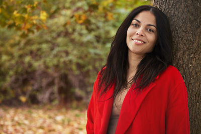 Young woman standing against plants