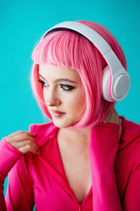 Portrait of young woman against blue background