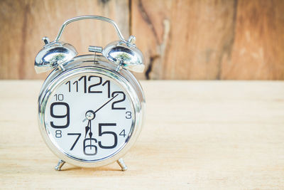 Close-up of alarm clock on wooden table