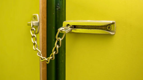 Close-up of chain lock on yellow door