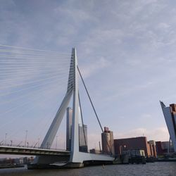 Suspension bridge over river against sky