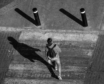 Man walking seen from a high angle view. hard shadows casting.